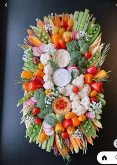 an arrangement of vegetables and dip on a black counter top with text overlaying the image