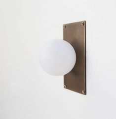 a light that is on the wall next to a white wall with a metal frame