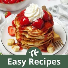 a stack of pancakes topped with strawberries and whipped cream