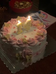 a birthday cake with the number forty on it and lit candles in front of a bowl of cookies