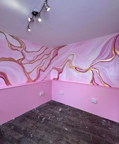 an empty room with pink and gold paint on the walls