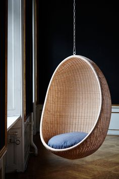 a hanging chair with blue cushions in a room