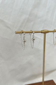 A handmade pair of silver dainty chain earrings adorned with 2 sterling silver beads . These minimalist style earrings are tarnish resistant and perfect for everyday and special occasions. They would make a great Gift for Mom, Sister, Wife, daughter or friend. HOW TO ORDER: Select the metal type in the drop down box and add to cart! 💍PRODUCT DETAILS - 1.3mm cable chain - 3mm ball atatched to post  - 5mm ball atattched to chain -materials: 14k gold filled or sterling silver post, chain and beads Minimalist Silver Jewelry With Dangling Beads, Silver Chain Earrings As A Gift, Silver Chain Earrings For Gift, Sterling Silver Chain Dangle Earrings, Dainty Silver Earrings With Adjustable Chain, Dainty Sterling Silver Chain Earrings, Chain Dangle Earrings For Gift, Dangle Chain Earrings As Gift, Silver Earrings With Beaded Chain For Party