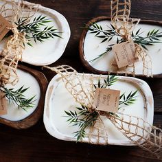 three small trays with tags and twine tied to them on a wooden table