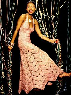 a woman in a pink dress is posing for a photo with streamers behind her