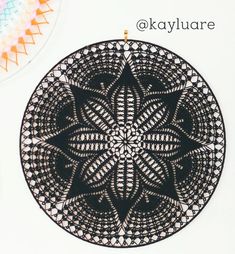 a black and white circular doily with the words, okayluare on it