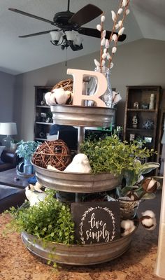 a living room filled with furniture and decor on top of a wooden table next to a ceiling fan