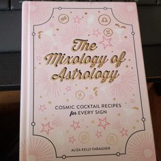 the front cover of a cookbook with pink and gold lettering on it that reads, the microloy of arrangcy cosmic cocktail recipes for every sign