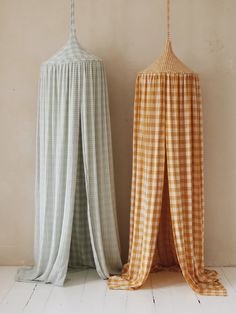 two drapes sitting next to each other on top of a white floor covered in gingham