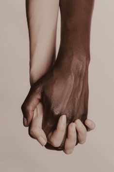 a black and white photo of two hands holding each other