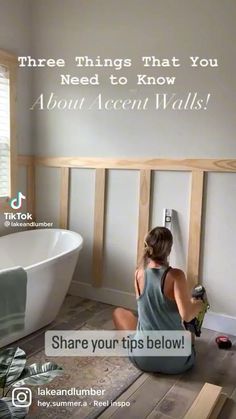 a woman sitting on the floor in front of a bathtub and wall decal