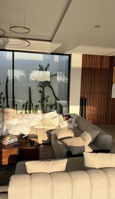 a living room filled with lots of furniture and large windows that look out onto the ocean