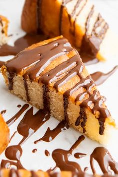 a piece of cake with chocolate drizzled on it and two slices cut out