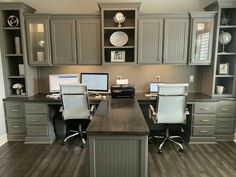 a home office with gray cabinets and white chairs