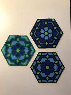 three hexagons made out of beading on a white surface with green and blue designs