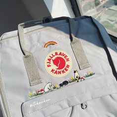 a bag with patches on it sitting next to a window