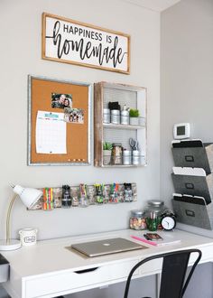 a desk with a laptop computer on top of it next to a wall mounted calendar