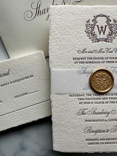 two wedding cards with a wax seal on them