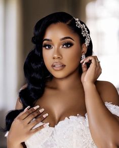 a woman in a wedding dress posing with her hands on her shoulder and wearing a tiara