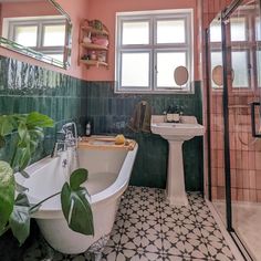 a bath tub sitting next to a white sink in a bathroom under two mirrors on the wall