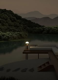 a couch sitting on top of a wooden table next to a body of water at night