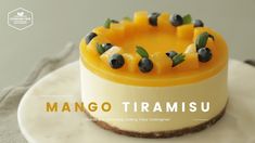 there is a small cake with fruit on it and the words mango tramisiu