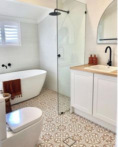 a bathroom with a toilet, sink and bathtub next to a shower stall in the corner