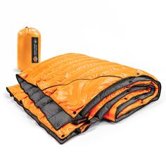 an orange sleeping bag with two pillows on it