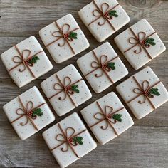 white square cookies decorated with brown ribbon and holly