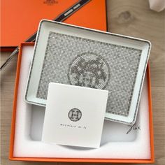 an orange and white box with a decorative design on it, next to a notepad