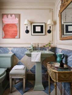 a bathroom with blue and white tiles on the floor, sink, toilet and mirror