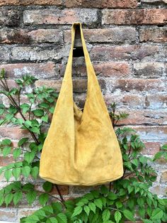 Slouch bag. LARGE tote leather bag in MUSTARD YELLOW Natural genuine SUEDE leather HOBO bag.  NOT LINED.  We added  a small leather zipper pouch for your mobile phone and/or cards or money.  It ist attached to the inside of the bag by a metal chain. The bag is closed by a metal clip at the center.  Width : 42cm - 16,5 in Height at the center: 34 cm - 13, 5 inc Total height : 65,5 cm  - 26 inch This bag in different colors and other leather Bags by Good Times Barcelona:  https://www.etsy.com/shop Tote Leather Bag, Slouch Bag, Leather Zipper Pouch, Large Hobo Bag, Yellow Soft, Slouch Bags, Boho Handbags, Suede Bag, Bohemian Bags