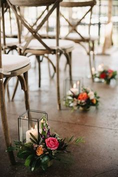 flowers and candles are placed on the floor next to chairs in front of them,