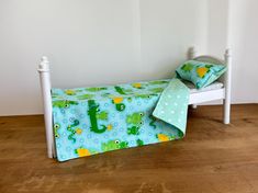 a child's bed with blue and green bedspread