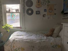 there is a bed in the room with many pictures on the wall and a teddy bear sitting on it