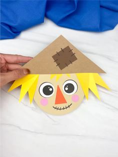 a paper doll made to look like a house with eyes and hair on it's head