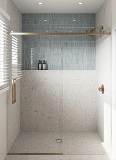 a bathroom with a glass shower door and white tile on the wall next to it