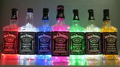 six bottles of whiskey are lit up with colored lights