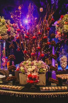 a table topped with lots of different types of flowers and desserts on top of it