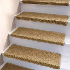 a set of beige carpeted stairs leading up to the top