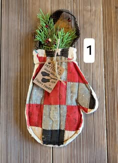 an oven mitt with a potted plant in it