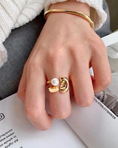 Handcrafted with 18K Gold Vermeil and a huge freshwater handpicked pearl, the Gold Resizable Pearl Ring was designed with modern architecture in mind. The ring can adjust to any finger size, at any time.  Note: Adjustable open ring, the size can be adjusted from size 4-9. ✨PRODUCT DETAILS✨ Materials: 18K Gold Vermeil Closure: Open Ring ✨Packing✨ Comes packaged in a luxury Myrage cream microfiber pouch, polishing cloth, care card, and a little something extra :) Orders with multiple pieces will i Modern Gold Pearl Ring, Care Card, Open Ring, Pearl Ring, Modern Architecture, Rings Statement, Gold Vermeil, Statement Rings, Jewelry Box