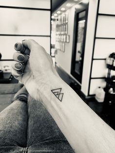 a person with a small triangle tattoo on their arm