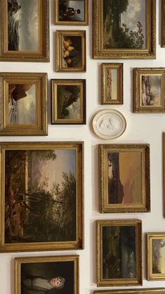 a wall with many paintings and clocks on it