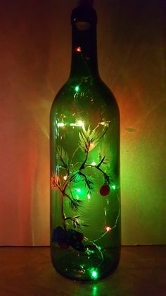 a green glass bottle with lights in it