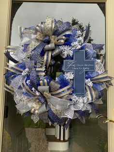 a blue and white wreath with a cross on it in front of a church door