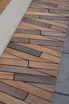 a close up view of a wooden bench on the sidewalk with no people around it