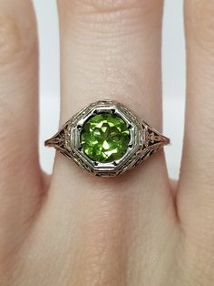 Once in a Blue Moon beautiful vintage finds. Antique Peridot Filigree Ring // Solid 925 Sterling Silver. Antique Remake. Ethical, lab created gemstone. Elegant mid-century style filigree and carving. Size: 6, 8, 9, 10 US * Message me for sizing options Weight: 2.0 g Stone: 1.0 ct (6.5 mm) Band width: 1.2 mm Free shipping, comes packaged in a ring box ready to gift! Art Deco Green Jewelry With Round Cut, Art Deco Green Round Cut Jewelry, Vintage Sterling Silver Filigree Ring With Intricate Design, Vintage Sterling Silver Filigree Ring, Antique May Birthstone Jewelry For Formal Occasions, Vintage White Gold Filigree Jewelry, Classic Peridot Jewelry For Formal Occasions, Art Deco Green Jewelry For Anniversary, Classic Green Filigree Ring With Gemstone