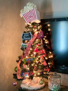 a christmas tree decorated with candy, popcorn and other items in front of a flat screen tv