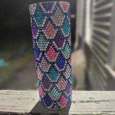 a colorful vase sitting on top of a wooden table